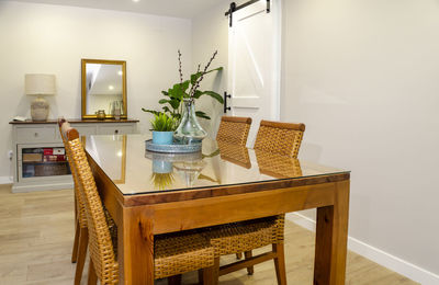 Bright dining room with a wooden table and rattan chairs.