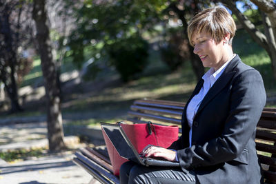 Young man using laptop while sitting in park