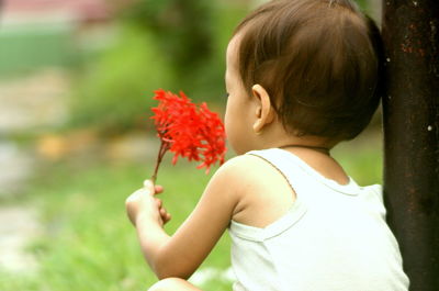 Girl holding ixora flowers in park