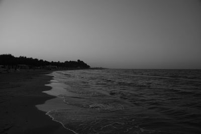 Scenic view of beach against clear sky during sunset