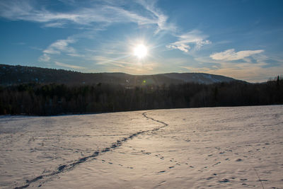 Scenic view of snowcapped field against sky during winter