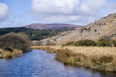 Scenic view of river amidst mountains against sky