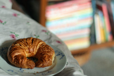 Close-up of croissant on plate in bed 