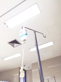 Low angle view of illuminated lighting equipment hanging on ceiling