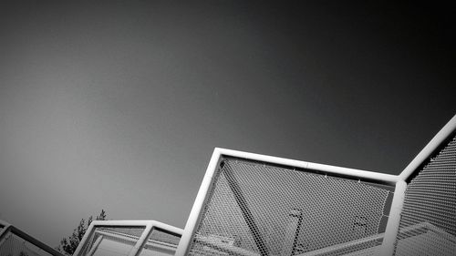 High section of metallic fence against clear sky