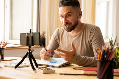 Portrait of artist male. smiling, making online art class. zoom remote learning. real emotions.