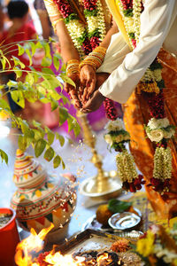 Midsection of couple performing ritual in wedding