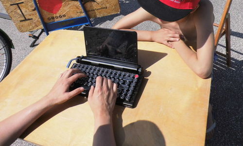 Hands typing on a very special laptop formed as a classic typewriter 