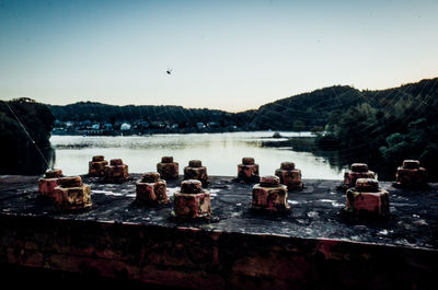 Rusty nuts of bridge scenic view of lake against clear sky