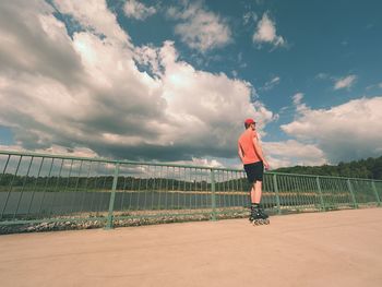 Full length of man standing by railing against sky