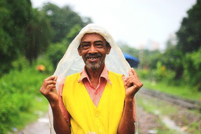 Portrait of a smiling young man in rain