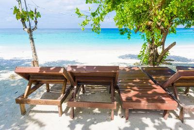 Empty chairs and table by swimming pool