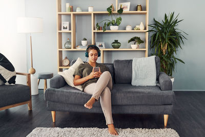 Young woman sitting on sofa at home