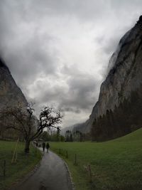 Empty road along landscape and mountains against sky