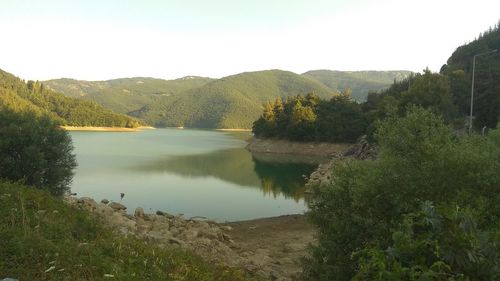 Scenic view of lake and mountains against clear sky