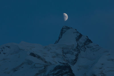 Scenic view of snowcapped mountains against sky at night