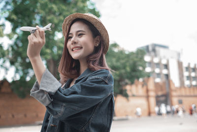 Portrait of smiling young woman standing outdoors