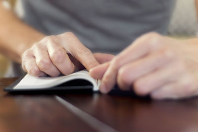 Close-up of man using smart phone on table