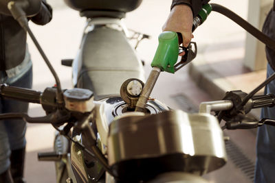 Cropped image of senior bikers refueling motorcycle at gas station