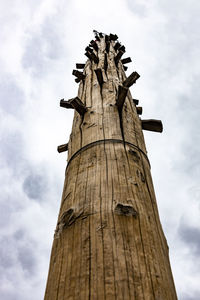 Low angle view of wooden post against sky