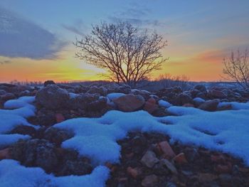 Snow covered landscape at sunset