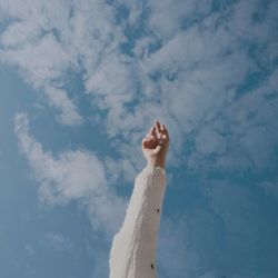 Low angle view of woman hand against sky