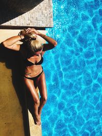 Woman in bikini relaxing at poolside