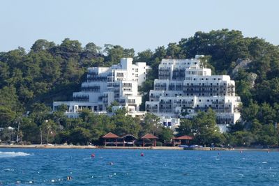 Scenic view of sea by buildings against sky