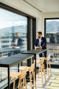 Businessman looking through window at cafe