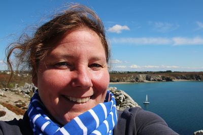 Portrait of smiling woman against sea