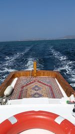 Close-up of boat sailing on sea against clear sky