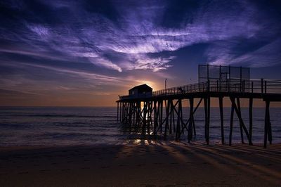 Pier on sea at sunset