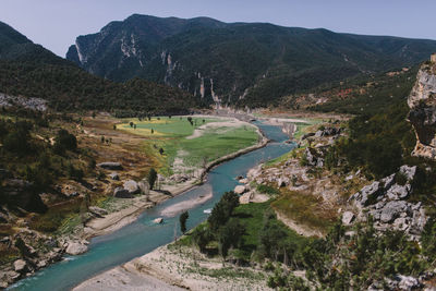 Scenic view of river by mountains against sky