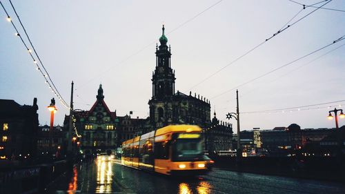 Cars on road in city against clear sky