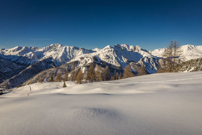 Scenic view of snowcapped mountains against clear sky