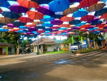 Multi colored umbrella on street amidst buildings in city