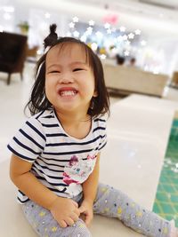 Portrait of a smiling girl sitting outdoors