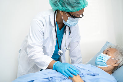 Portrait of doctor examining patient in hospital