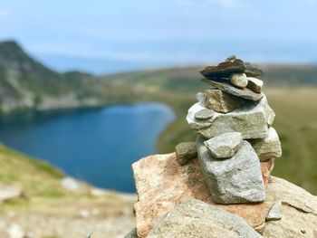 Close-up of stone stack on rock against sky