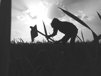 Silhouette of dog on field against sky