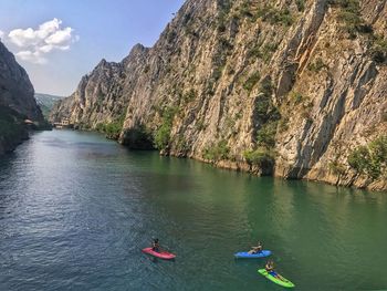 High angle view of male friends kayaking on river in valley