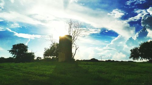 Scenic view of grassy field against cloudy sky