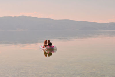 Woman lying in float at calm sea