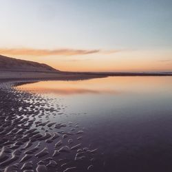 Scenic view of beach against sky during sunset