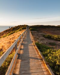 Footpath leading towards landscape against sky