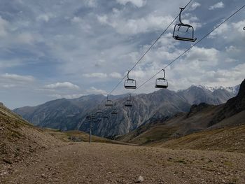 Overhead cable car over mountains against sky