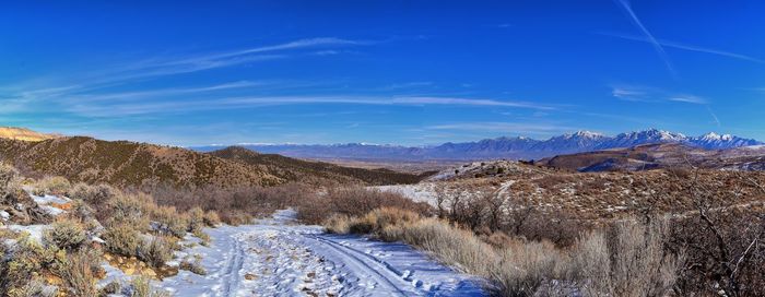 Scenic view of landscape and mountains against blue sky