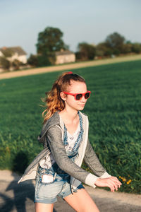 Teenage girl wearing sunglasses while walking on land