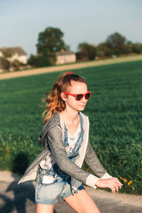 Young woman wearing sunglasses on field