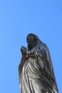 Low angle view of statue against clear blue sky